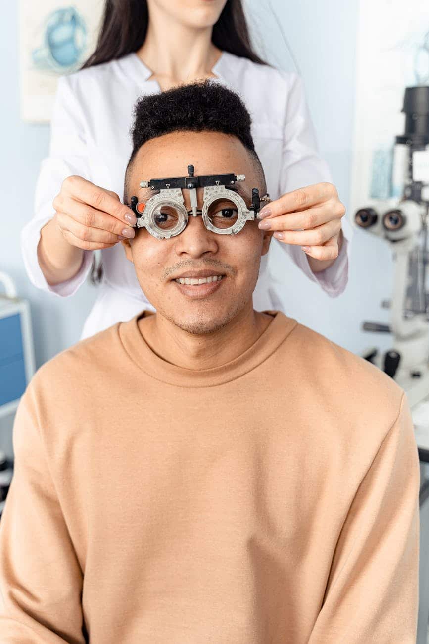doctor putting an optical trial lens frame on a patient
